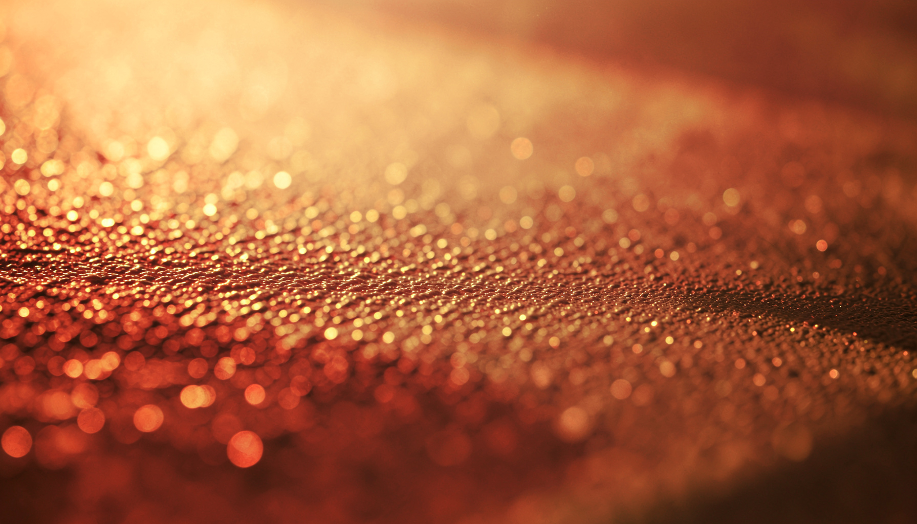 Vue rapprochée d'une surface métallique texturée sous lumière rasante dorée, évoquant la science des matériaux à l'échelle microscopique.